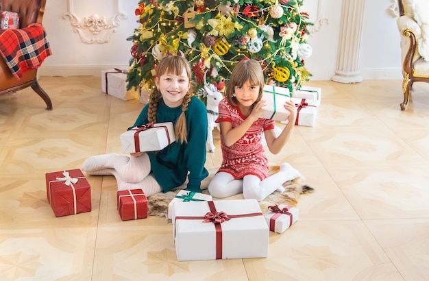 Kinder in der Nähe des Weihnachtsbaumes. Tiefenschärfe.