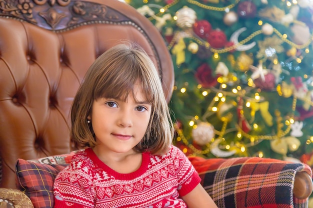 Kinder in der Nähe des Weihnachtsbaumes. Tiefenschärfe.