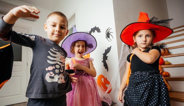 Kinder in Feiertagskostümen warten auf Halloween-Leckereien