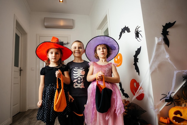 Foto kinder in feiertagskostümen warten auf halloween-leckereien