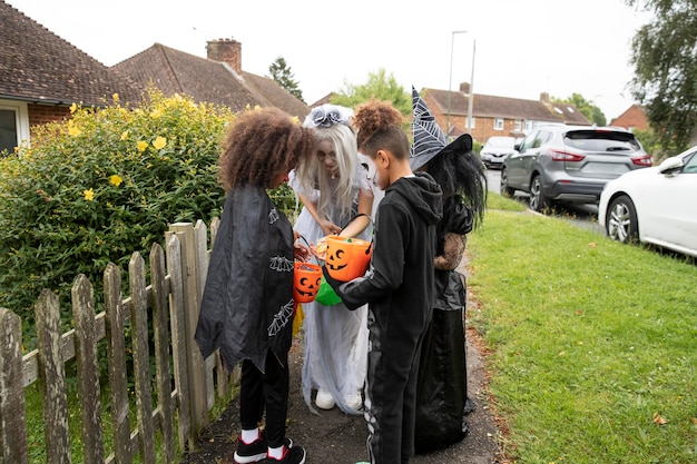 Foto kinder in kostümen, die an halloween auf ihre süßigkeiten schauen