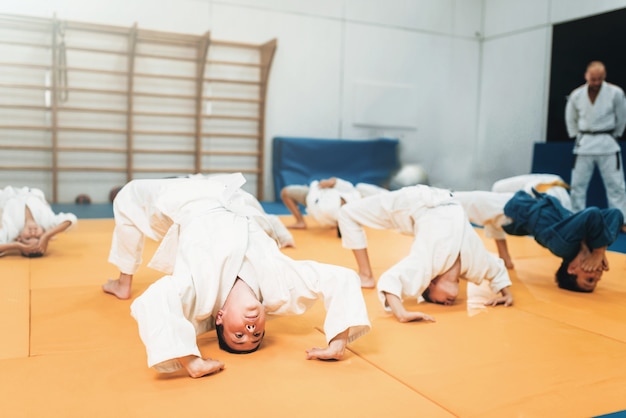 Kinder Judo, Kinder im Kimono üben Kampfkunst im Fitnessstudio. Kleine Jungen und Mädchen in Uniform beim Sporttraining