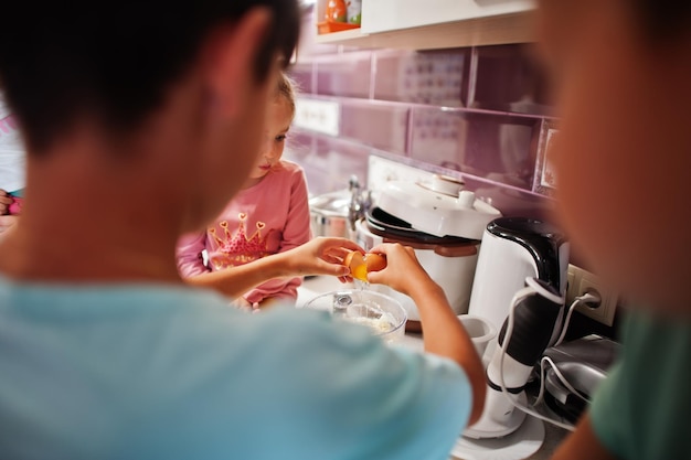 Kinder kochen in der Küche glückliche Kindermomente Knacken Sie ein Ei