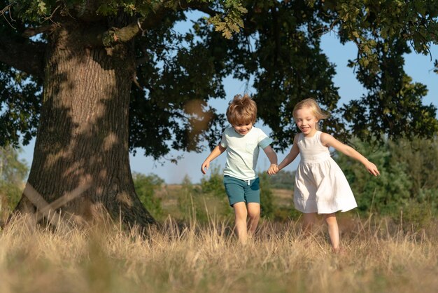 Kinder laufen auf dem Feld Kinderbauernkonzept glückliche Kinderbauern, die auf Frühlingsfie mit Spud arbeiten ...