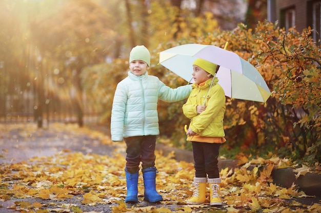 Kinder laufen im Herbst im Herbstpark