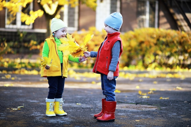 Kinder laufen im Herbst im Herbstpark