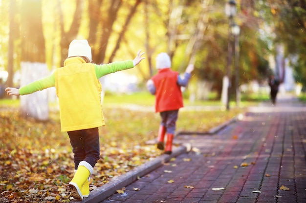 Kinder laufen im Herbst im Herbstpark