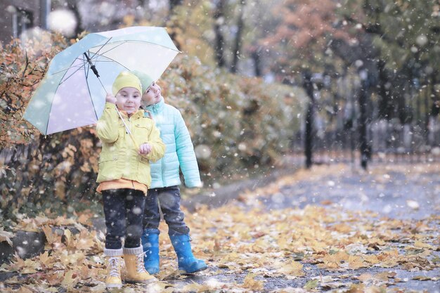 Kinder laufen mit dem ersten Schnee im Park