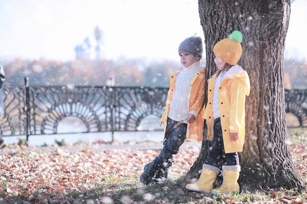 Kinder laufen mit dem ersten Schnee im Park