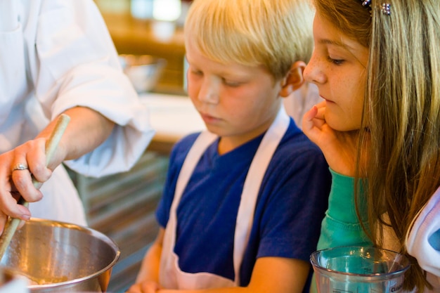 Kinder lernen in einem Kochkurs, wie man kocht.