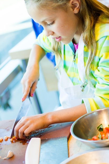 Kinder lernen in einem Kochkurs, wie man kocht.