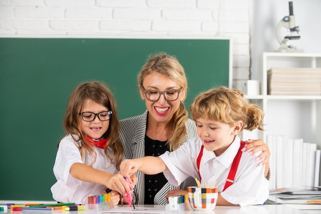 Kinder lernen mit Lehrerkindern aus der Grundschule lernen im Unterricht Junge und Mädchen mit Lehrer