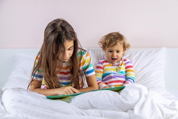 Kinder lesen ein Buch im Bett Selektiver Fokus