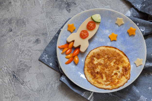 Kinder lustiges Frühstück mit Käsesandwich und einem Omelett