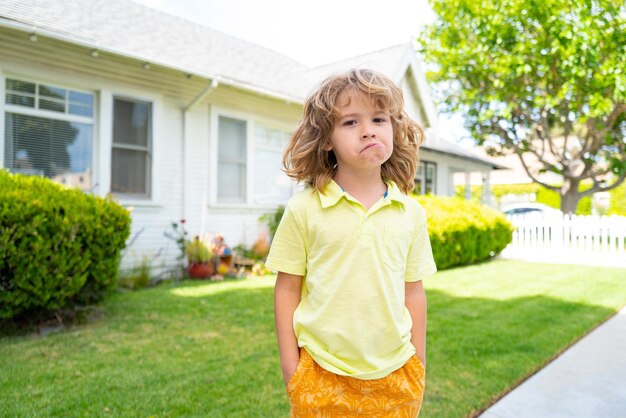 Kinder lustiges Gesicht glückliches Kind, das Spaß hat und draußen lustige Gesichter macht