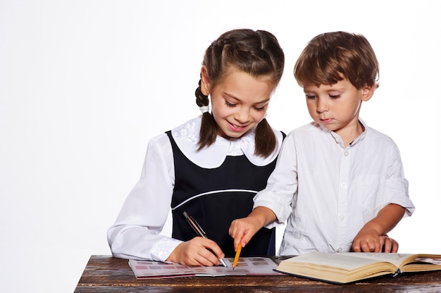 Kinder machen eine Hausarbeit auf Studiohintergrund.