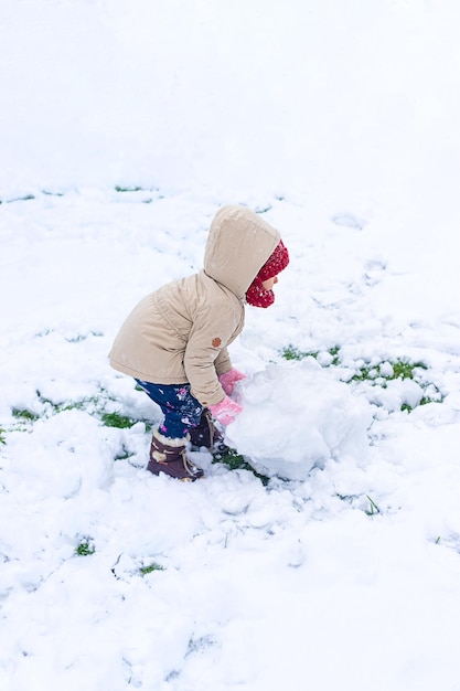 Kinder machen im Winter einen Schneemann Selektiver Fokus