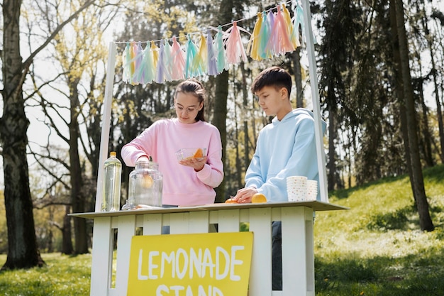 Foto kinder machen limonade im freien, mittlerer schuss