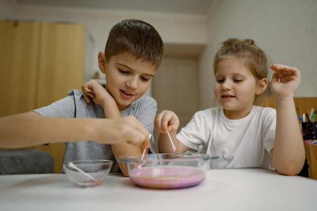 Kinder Mädchen Junge haben Spaß zu Hause beim Experimentieren mit Milch und Farben
