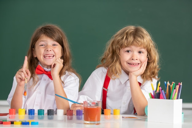 Kinder Mädchen und Jungen zeichnen mit Farbstiften Süße Schulkinder malen im Unterricht in der Schule