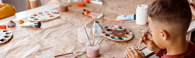 Kinder malen auf Papier mit bunten Farben