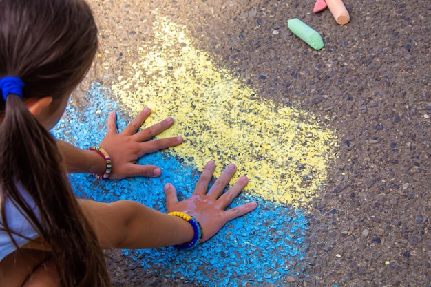 Kinder malen einen Regenbogen auf den Asphalt Selektiver Fokus