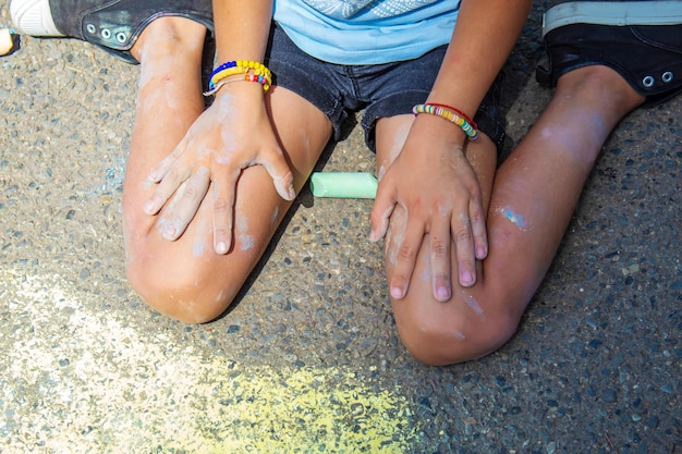 Kinder malen einen Regenbogen auf den Asphalt Selektiver Fokus