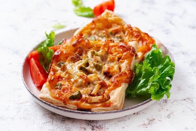 Kinder-Mini-Pizza kleine offene Kuchen mit Schinken-Tomaten-Sauce-Mozzarella und Käse im Korb auf hellem Hintergrund