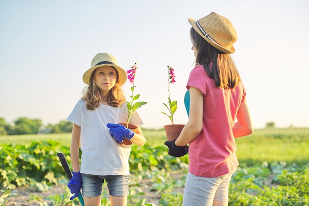 Kinder mit Blumen in Töpfen, Handschuhe mit Gartengeräten