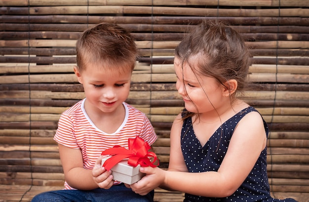 Kinder mit Geschenkbox auf Holz