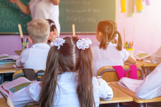 Kinder nehmen aktiv am Unterricht teil, lesen und hören dem Lehrer zu.