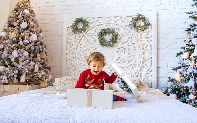 Kinder öffnen Weihnachtsgeschenke unter dem Baum Selektiver Fokus