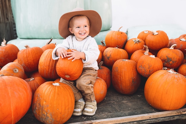 Kinder pflücken Kürbisse auf dem Bauernmarkt Thanksgiving-Ferienzeit und Halloween