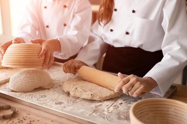 Kinder rollen Teig und backen Brot