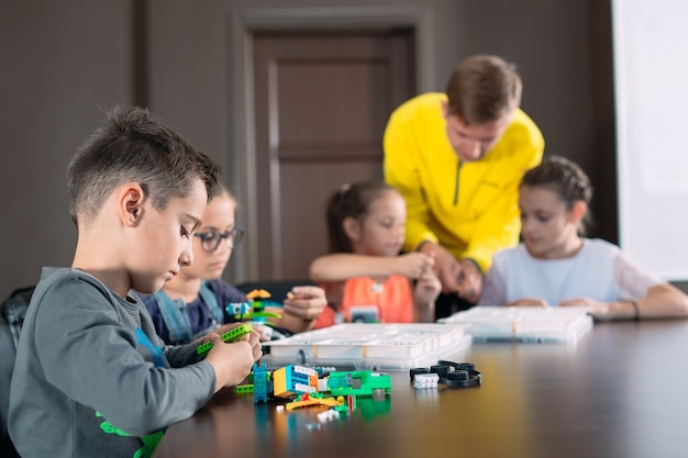 Kinder schaffen Roboter mit Lehrer.