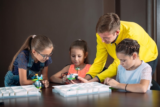 Kinder schaffen Roboter mit Lehrer.