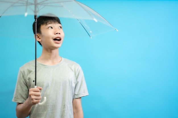 Kinder schließen Foto von süßen und fröhlichen Menschen, die einen Regenschirm halten und lächeln