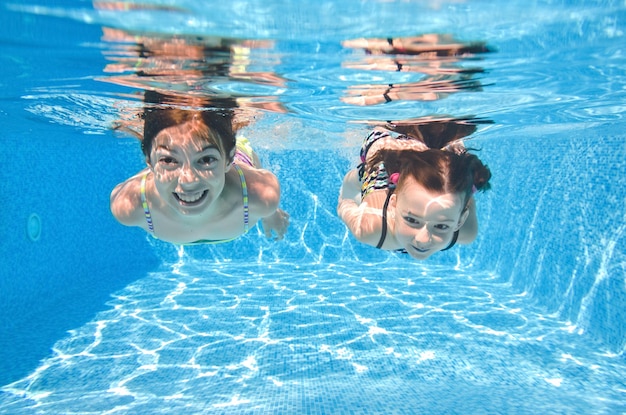 Kinder schwimmen im Schwimmbad unter Wasser kleine aktive Mädchen haben Spaß unter Wasser Kinder Fitness