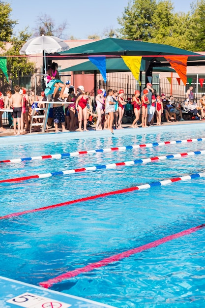 Kinder schwimmen im Sommer im Außenpool.