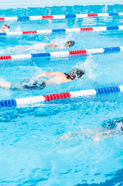 Kinder schwimmen im Sommer im Außenpool.