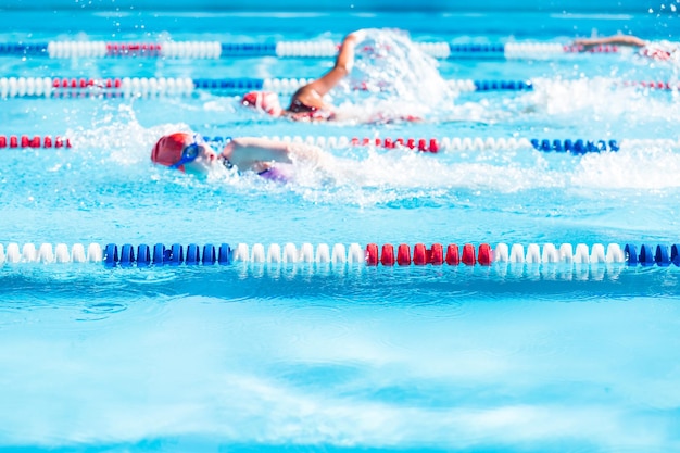 Kinder schwimmen im Sommer im Außenpool.