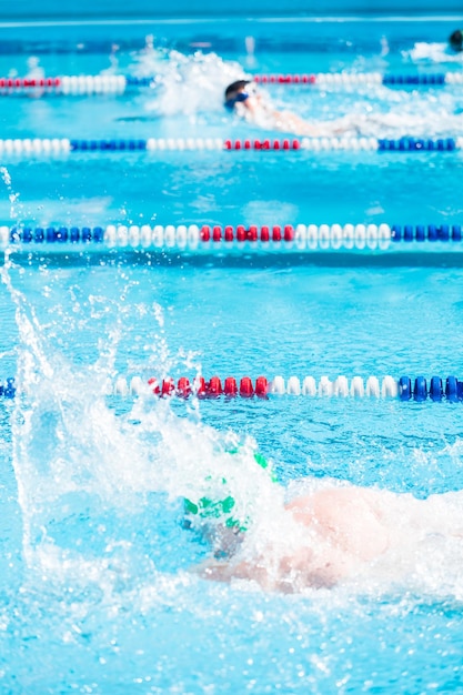 Kinder schwimmen im Sommer im Außenpool.