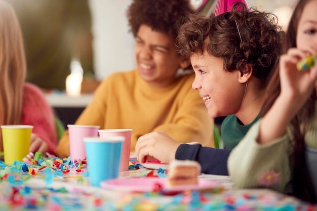 Kinder sitzen am Tisch Freunde feiern auf der Geburtstagsfeier mit Freunden zu Hause