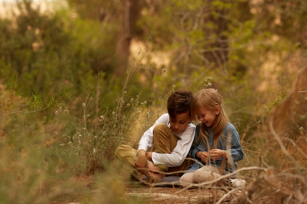 Kinder sitzen auf dem Boden in der Natur