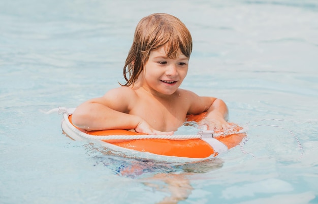 Kinder Sommerferien Pool Resort Junge Spaß im Aquapark glückliches Kind spielt mit Schwimmring l ...
