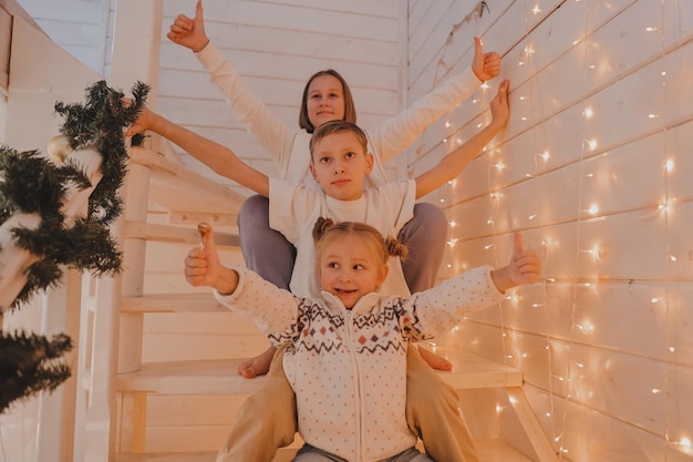 Kinder spielen auf der weihnachtlich dekorierten Treppe im Neujahrshaus, Familie, Winterurlaub und Menschenkonzept