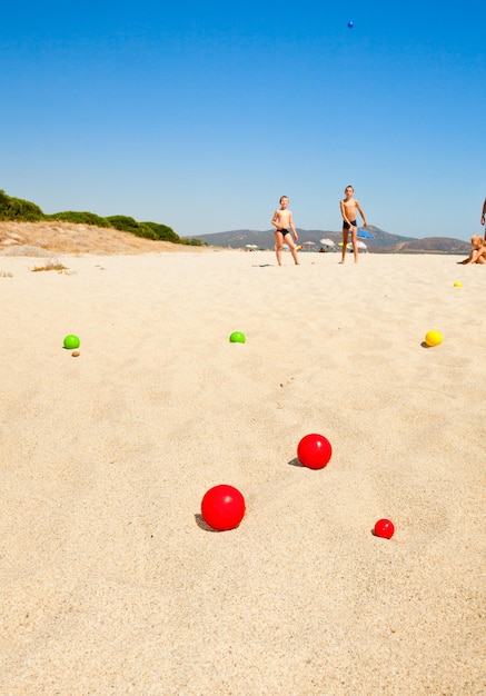 Kinder spielen auf einem Strand Boules