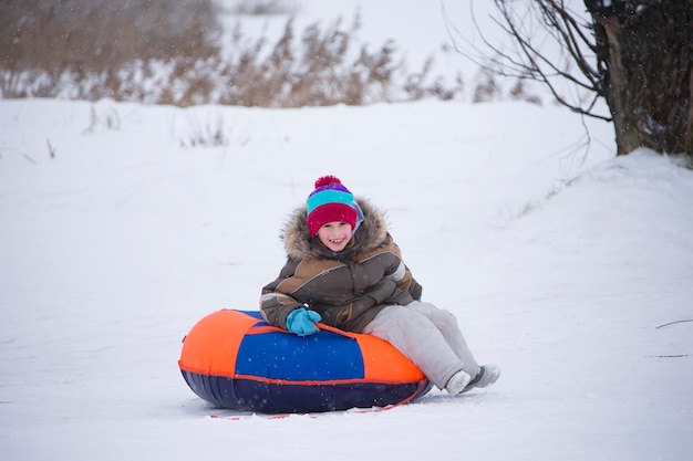 Kinder spielen draußen im Schnee Kinderschlitten in den Alpenbergen im Winter