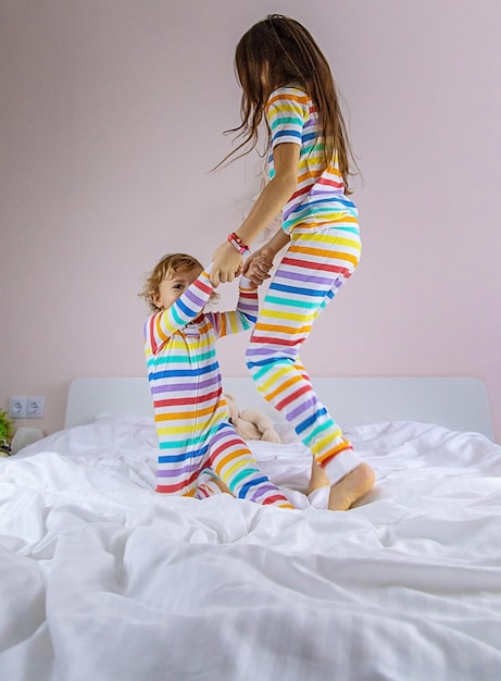 Kinder spielen im Bett springen Selektiver Fokus