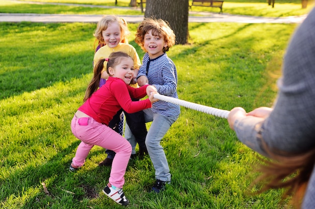 Kinder spielen im Park Tauziehen.